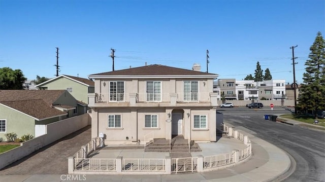 townhome / multi-family property with a fenced front yard and stucco siding