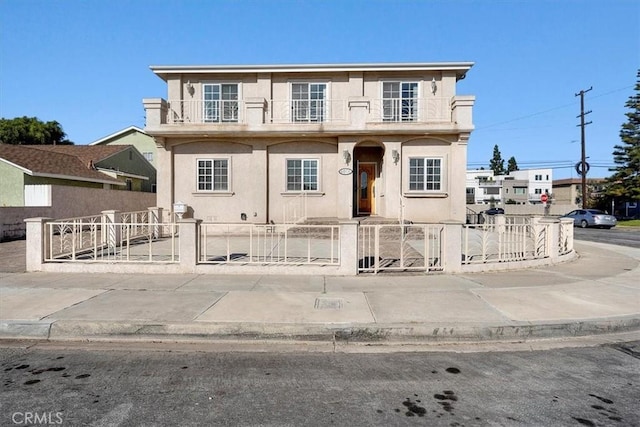 4601 W 191st St, Torrance, CA 90503 - view of front facade featuring a balcony, a gate, a fenced front yard, and stucco siding