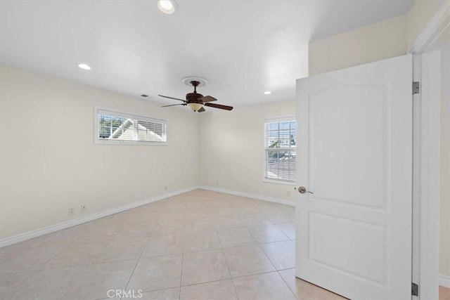 unfurnished room featuring light tile patterned floors, recessed lighting, baseboards, and a wealth of natural light