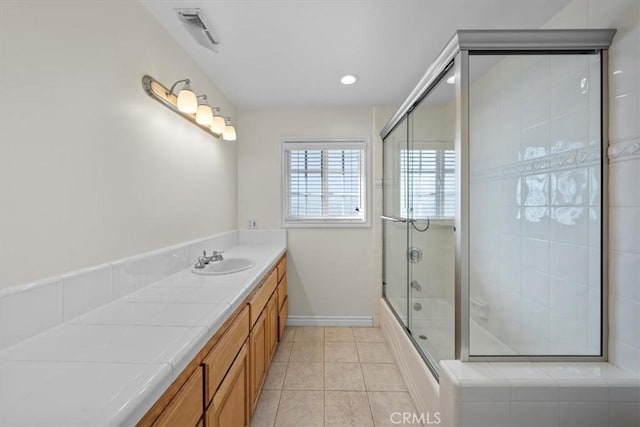 bathroom with vanity, baseboards, visible vents, bath / shower combo with glass door, and tile patterned floors