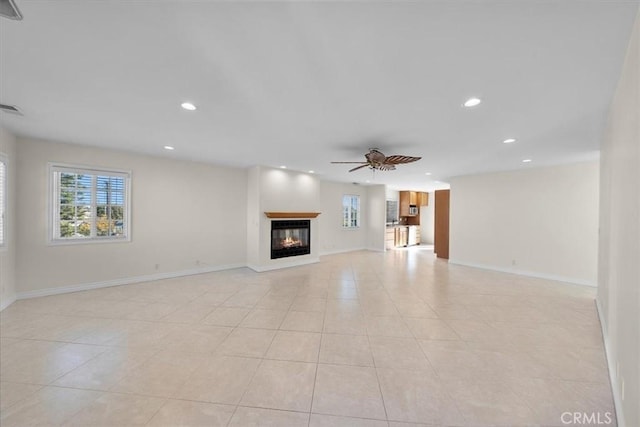 unfurnished living room featuring baseboards, recessed lighting, light tile patterned flooring, a glass covered fireplace, and a ceiling fan