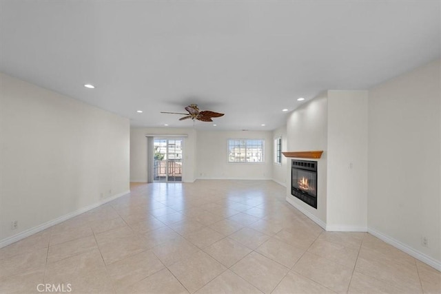 unfurnished living room featuring recessed lighting, baseboards, a glass covered fireplace, and a ceiling fan