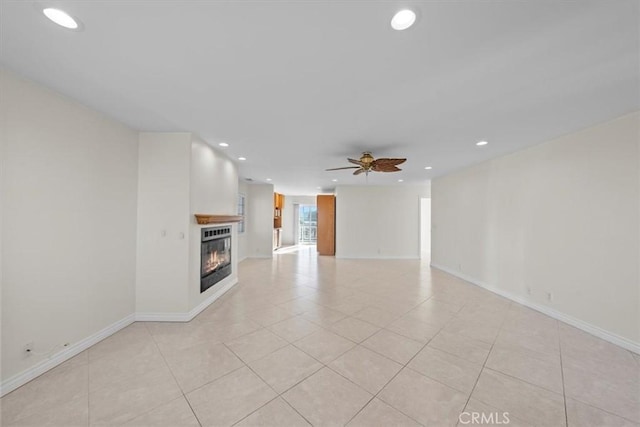 unfurnished living room featuring a ceiling fan, a glass covered fireplace, recessed lighting, light tile patterned floors, and baseboards