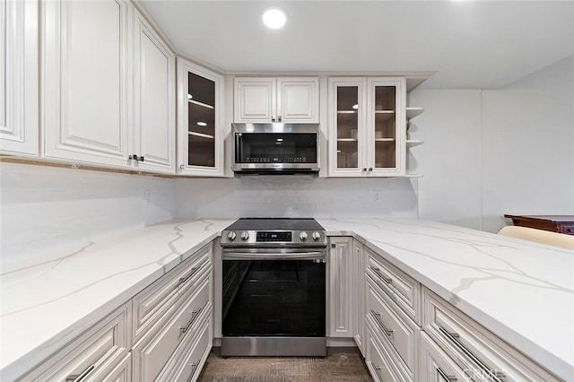 kitchen with white cabinetry, light stone countertops, and stainless steel appliances