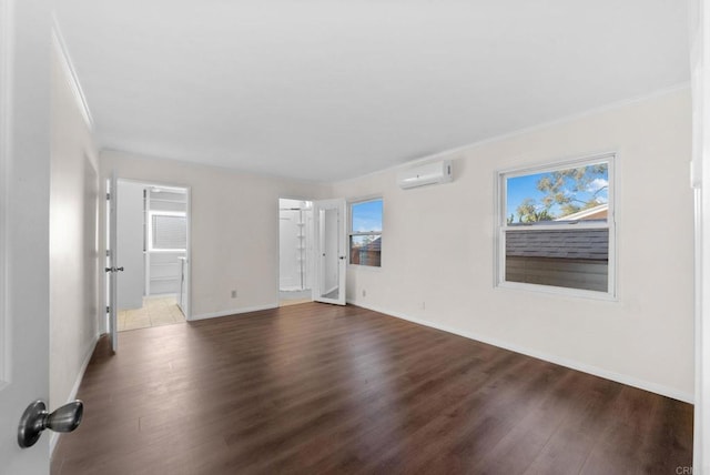 unfurnished room featuring wood-type flooring, crown molding, and an AC wall unit