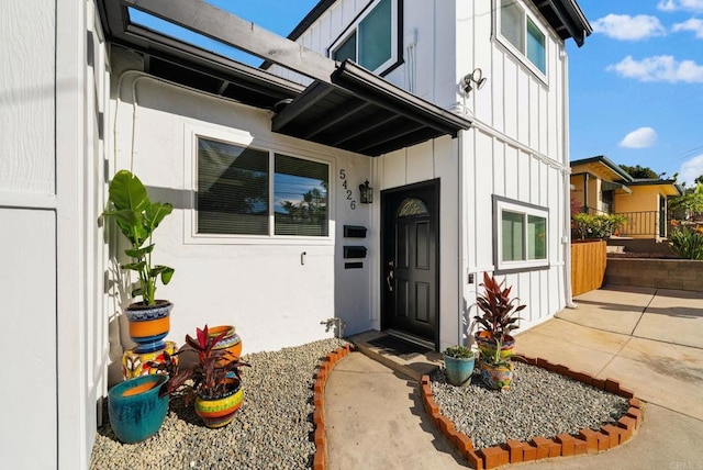 view of exterior entry with a patio area