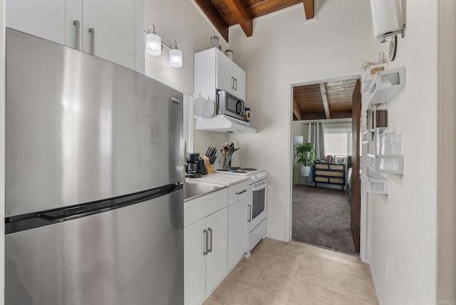 kitchen with beam ceiling, stainless steel appliances, light colored carpet, white cabinets, and wood ceiling