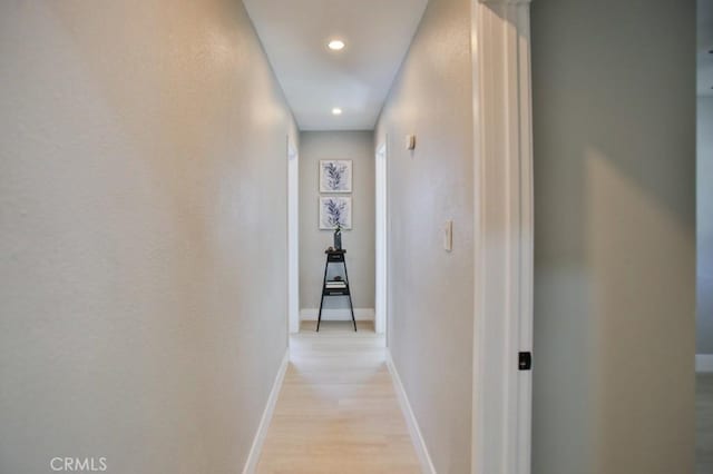 corridor featuring light wood finished floors, baseboards, and recessed lighting