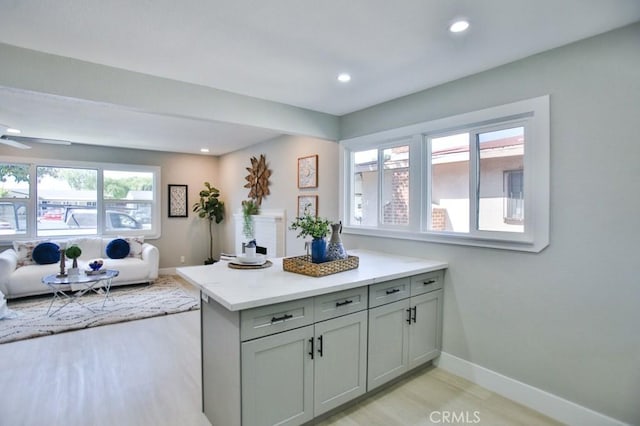 kitchen with recessed lighting, light wood-style flooring, gray cabinetry, open floor plan, and baseboards