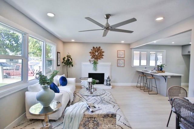 living area with recessed lighting, baseboards, and light wood finished floors