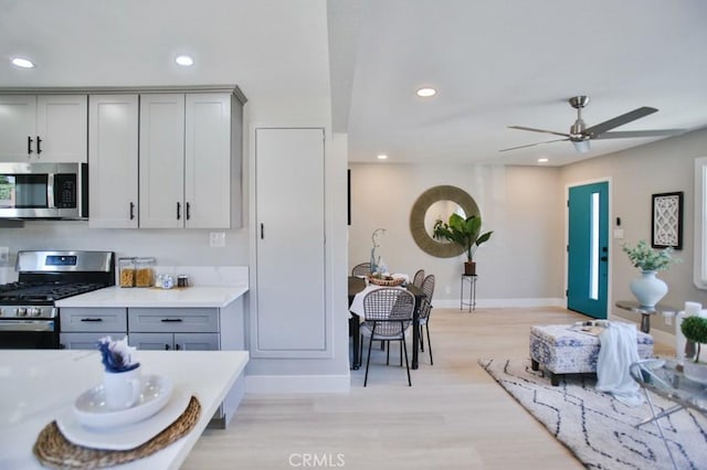 kitchen featuring stainless steel appliances, recessed lighting, light countertops, and gray cabinetry