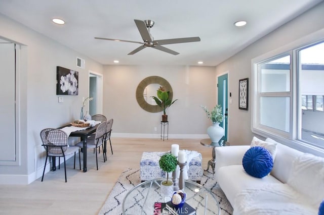 living area featuring light wood-type flooring, recessed lighting, visible vents, and baseboards