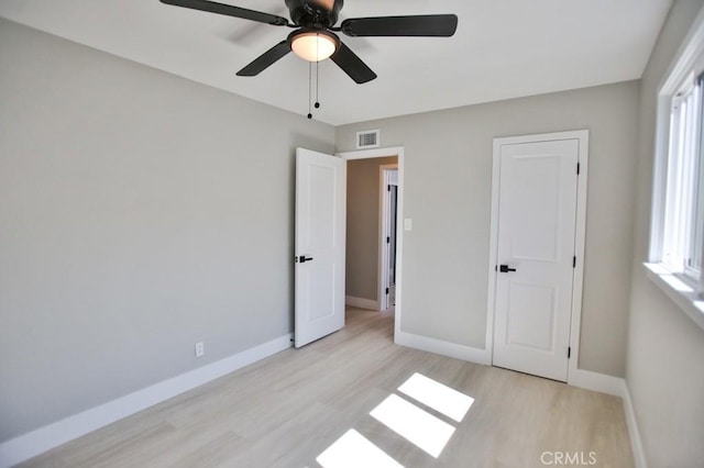 unfurnished bedroom with light wood-type flooring, visible vents, ceiling fan, and baseboards