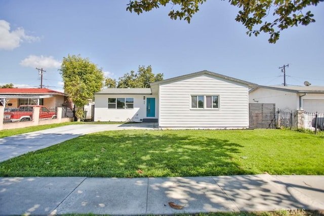 single story home with driveway, fence, and a front yard