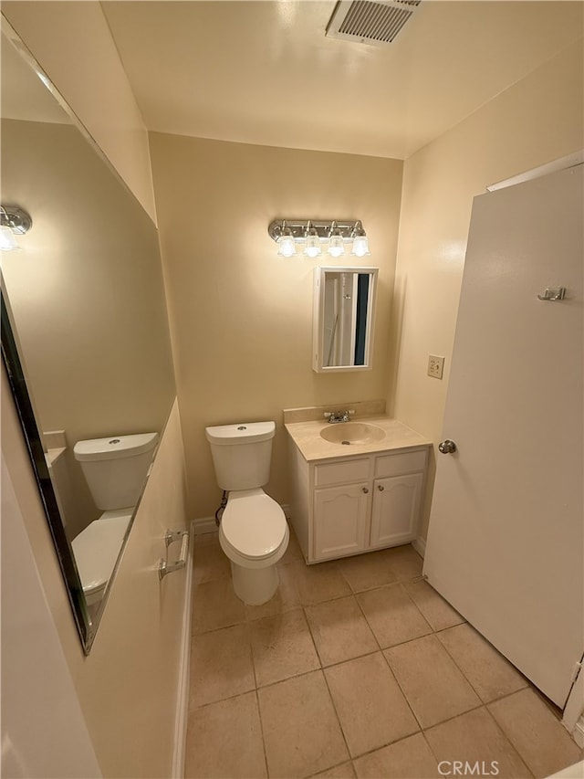 bathroom with tile patterned flooring, vanity, and toilet