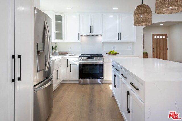 kitchen featuring pendant lighting, stainless steel appliances, and white cabinetry