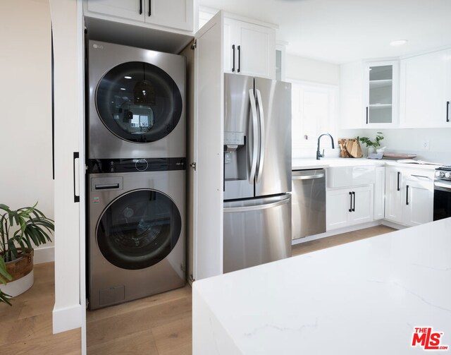 washroom featuring light wood-type flooring and stacked washer and dryer