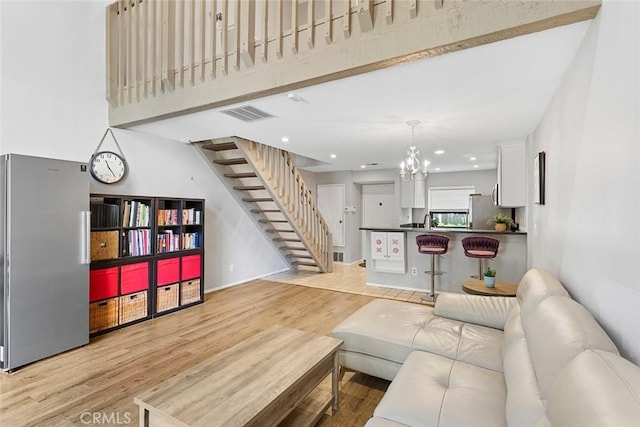 living room featuring a chandelier and light hardwood / wood-style floors