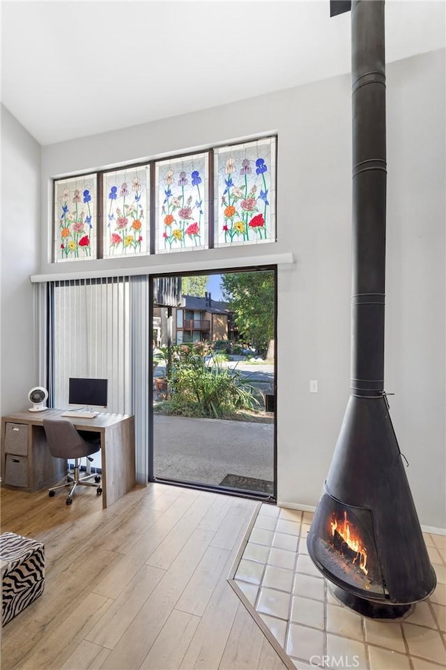 interior space with light hardwood / wood-style floors and a wood stove