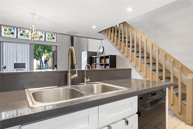 kitchen with sink, light tile patterned floors, decorative light fixtures, white cabinets, and black dishwasher