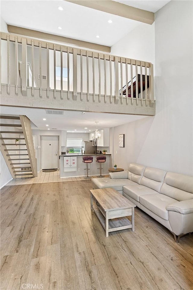 unfurnished living room with light wood-type flooring and a chandelier