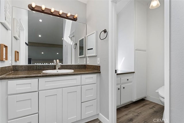 bathroom featuring hardwood / wood-style floors, vanity, and toilet