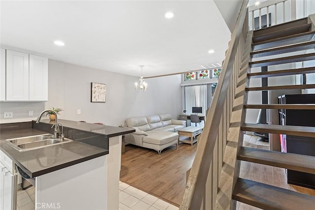 kitchen featuring kitchen peninsula, sink, white cabinets, and light hardwood / wood-style floors