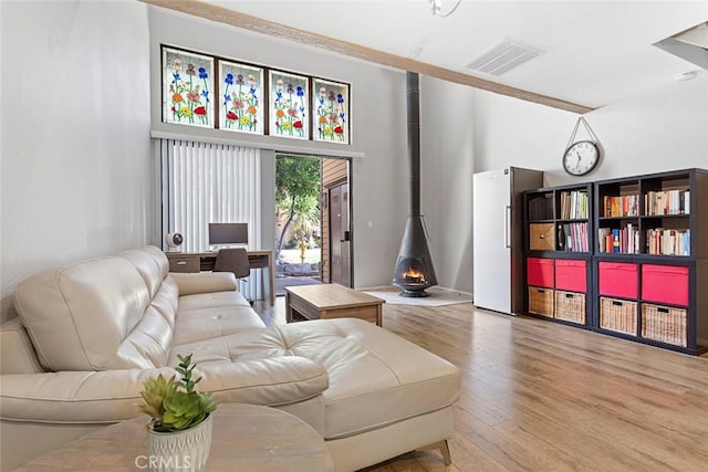 living room with light hardwood / wood-style floors and a wood stove