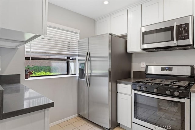 kitchen featuring white cabinets, light tile patterned floors, and stainless steel appliances