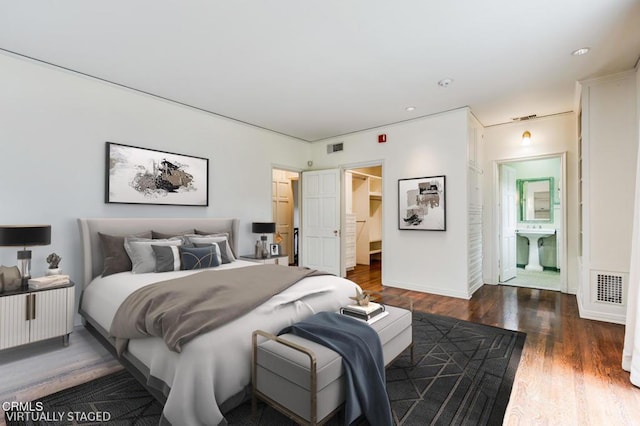 bedroom featuring dark hardwood / wood-style flooring and connected bathroom