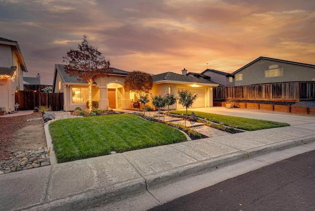 view of front of home with a lawn and a garage