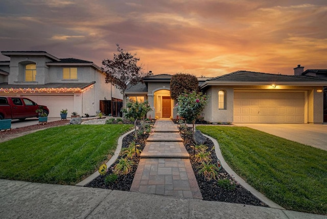 prairie-style home featuring a garage and a lawn