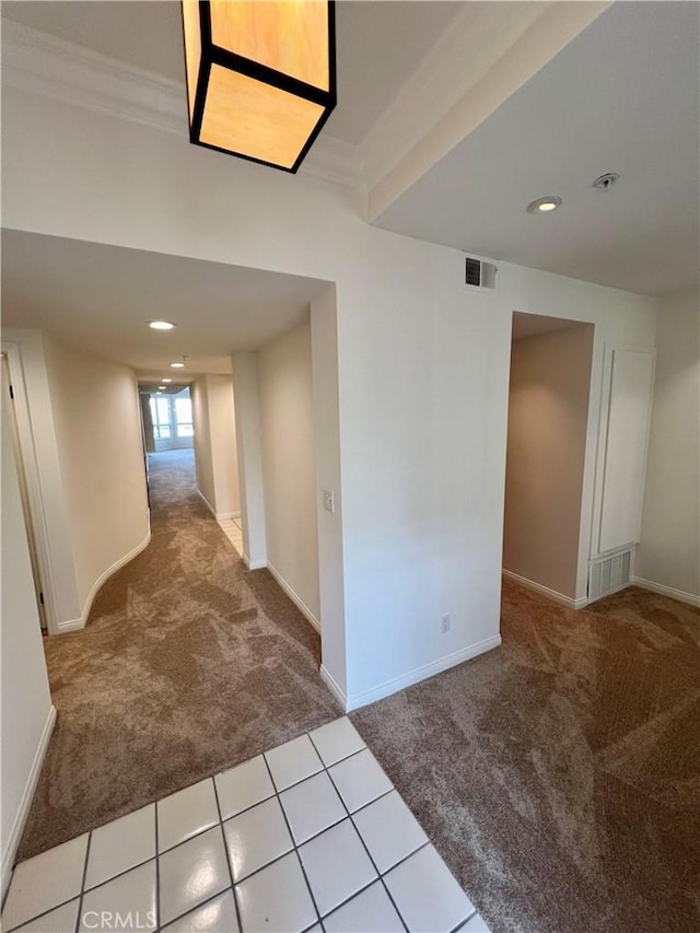 corridor featuring beam ceiling, light colored carpet, and ornamental molding