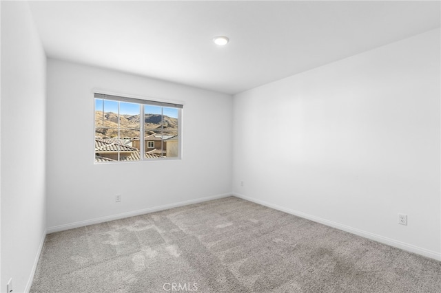 spare room featuring light carpet