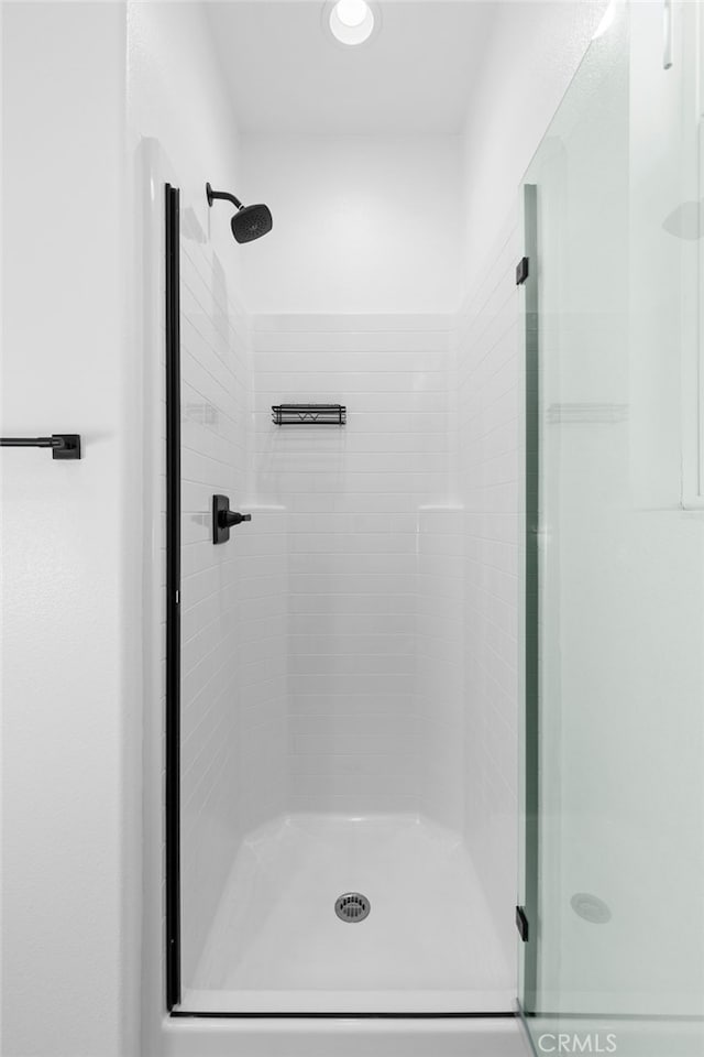 bathroom featuring a shower with shower door