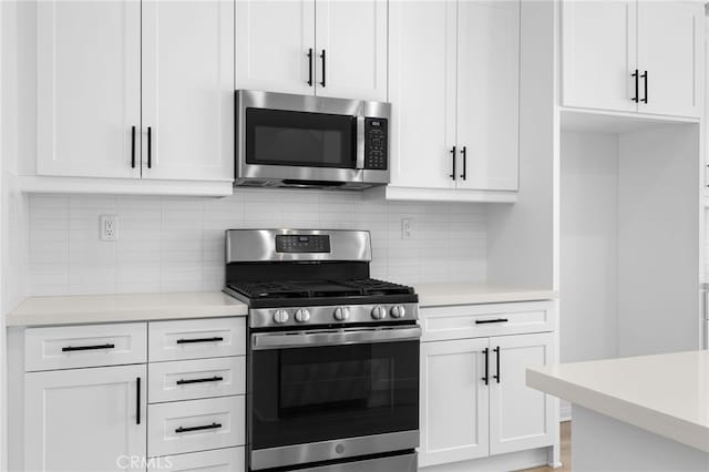 kitchen featuring tasteful backsplash, white cabinets, and stainless steel appliances