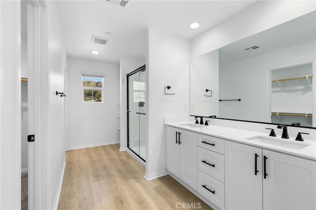 bathroom featuring hardwood / wood-style flooring, vanity, and walk in shower