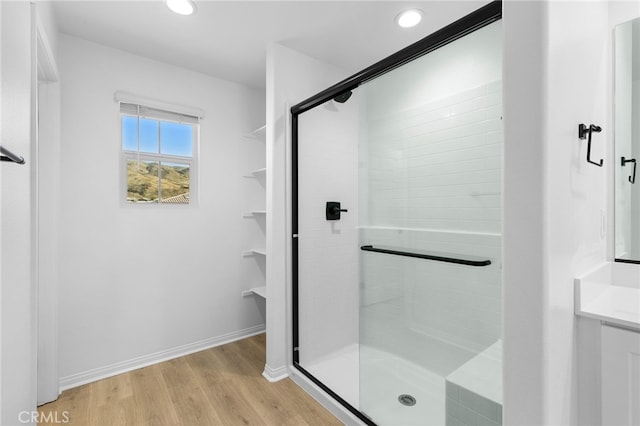 bathroom with hardwood / wood-style flooring and walk in shower