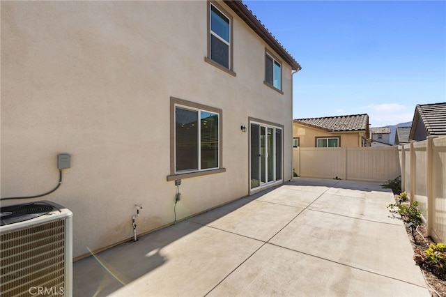 view of property exterior with a patio and central AC