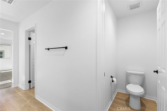 bathroom with wood-type flooring and toilet