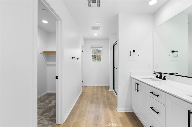 bathroom with vanity, wood-type flooring, and walk in shower