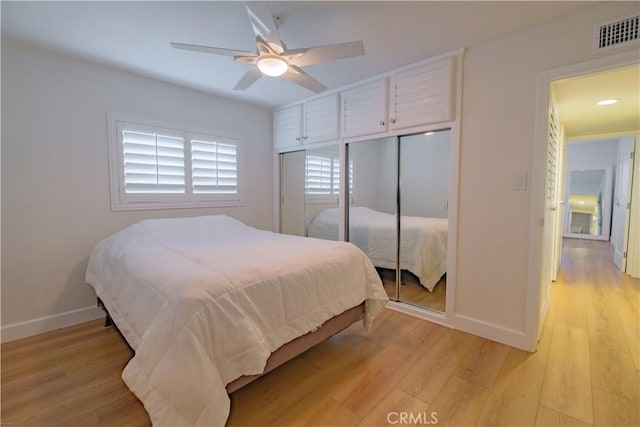 bedroom with light wood-type flooring, a closet, and ceiling fan