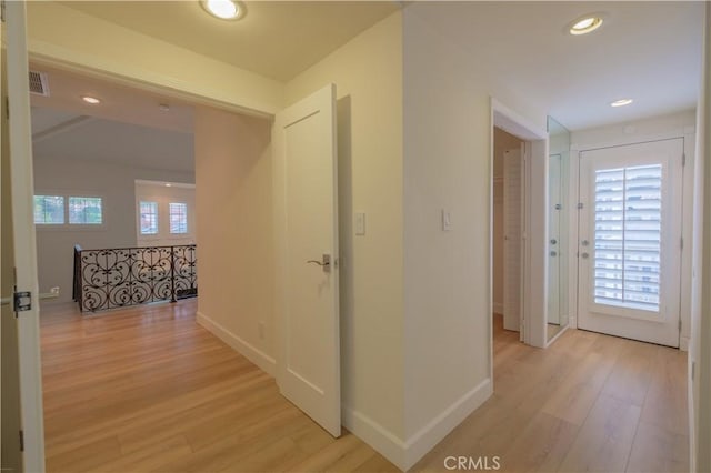 hall featuring plenty of natural light and light hardwood / wood-style floors