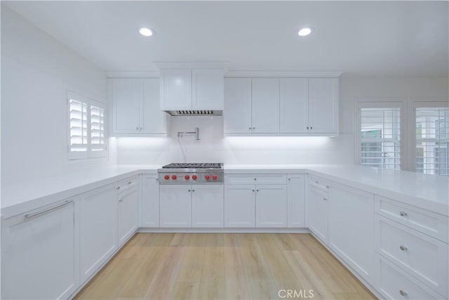 kitchen featuring white cabinets, stainless steel gas stovetop, and light hardwood / wood-style flooring