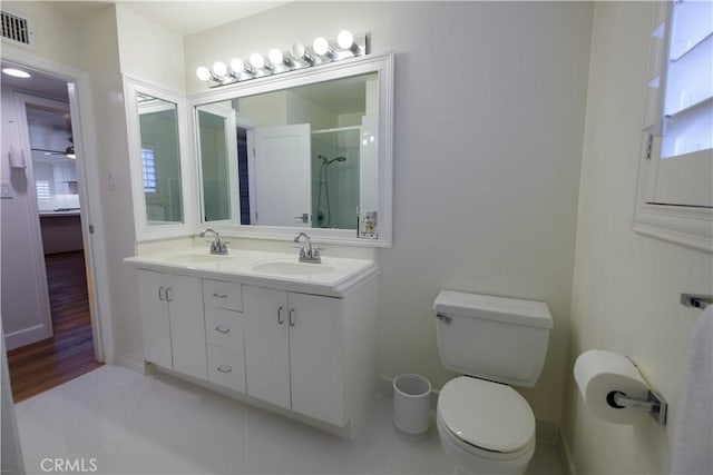 bathroom featuring toilet, vanity, tile patterned floors, and an enclosed shower