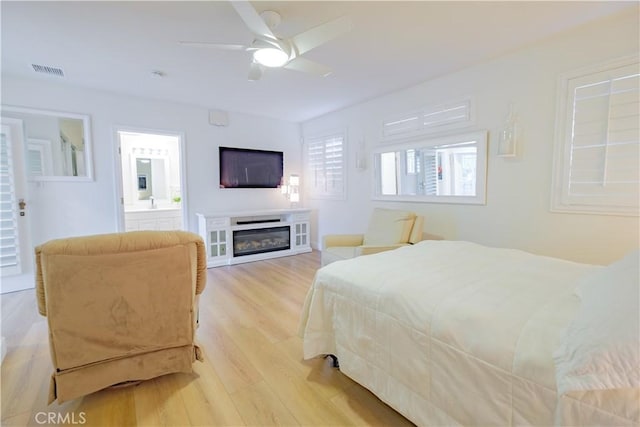 bedroom with light hardwood / wood-style floors, ceiling fan, and ensuite bathroom