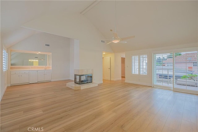 unfurnished living room with a multi sided fireplace, high vaulted ceiling, light hardwood / wood-style flooring, and ceiling fan