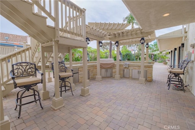 view of patio / terrace featuring a pergola and exterior kitchen