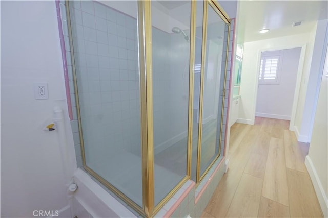 bathroom featuring an enclosed shower and hardwood / wood-style flooring