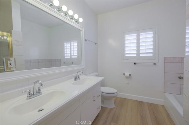 bathroom featuring hardwood / wood-style flooring, vanity, toilet, and walk in shower